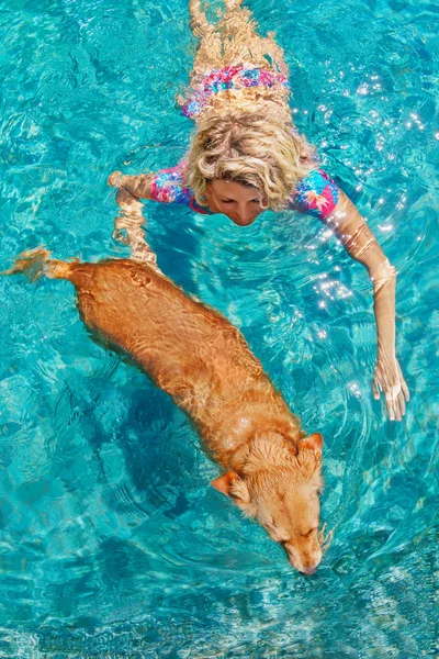 Beautiful woman young woman swim with dog in pool