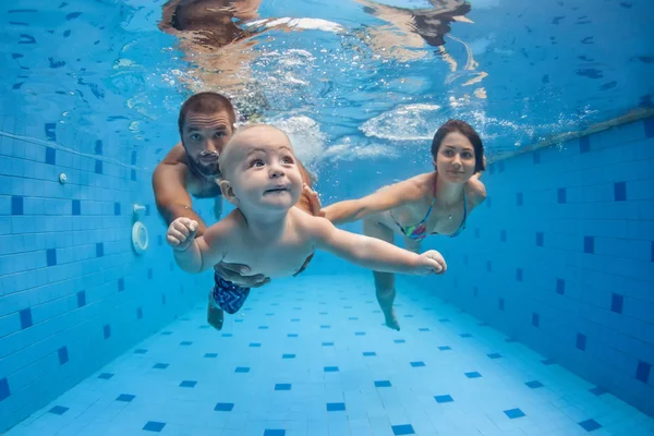 Happy full family swim and dive underwater in swimming pool