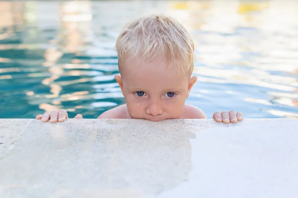 Portrait of funny little baby boy in swimming pool
