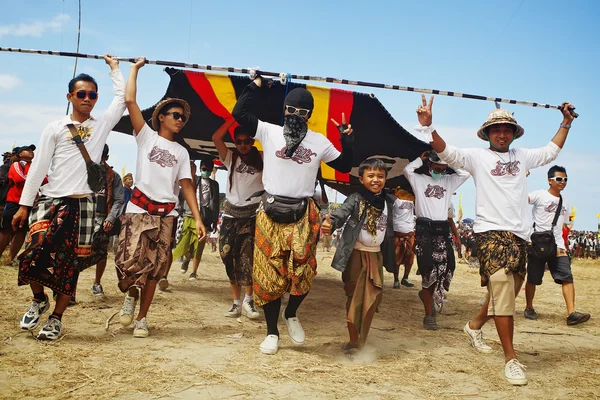 Unidentified young men carrying a huge kite