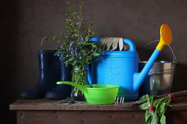 Garden still life with bouquet, watering can and Wellington boot