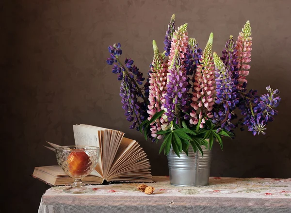 Still life bouquet with lupine and an open book.