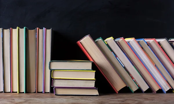 Books on the shelf in the background of a school blackboard.
