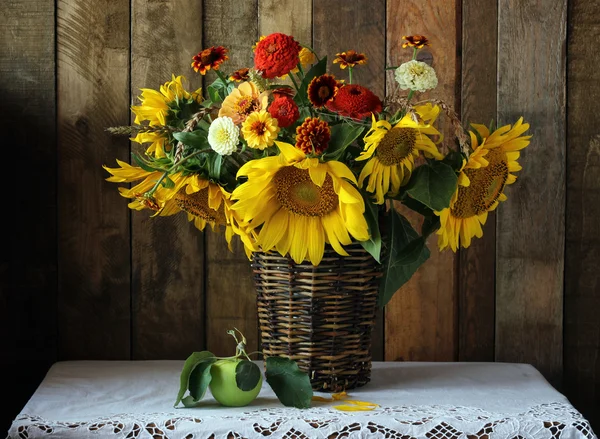 Still life with bouquet of sunflowers and green Apple.
