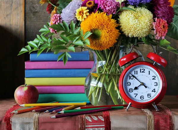 Bouquet and book. Back to school. Still life with a stack of boo