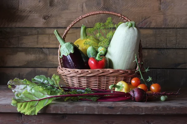 Basket with vegetables: vegetable marrow, pumpkin, eggplant, pepper, carrots, cucumbers and tomatoes. Vegetables in a basket.
