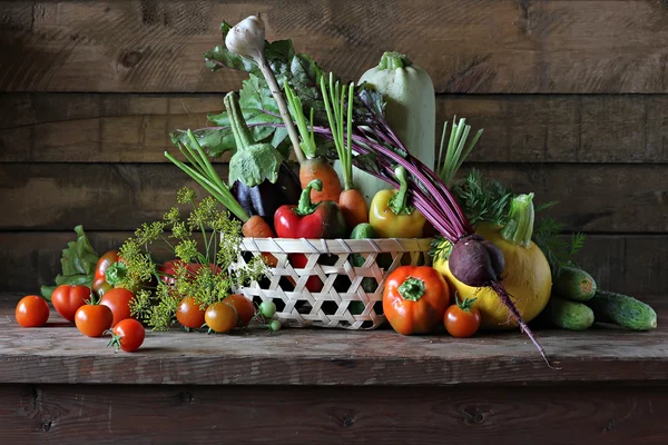 Basket with vegetables: vegetable marrow, pumpkin, eggplant, pepper, carrots, cucumbers and tomatoes.