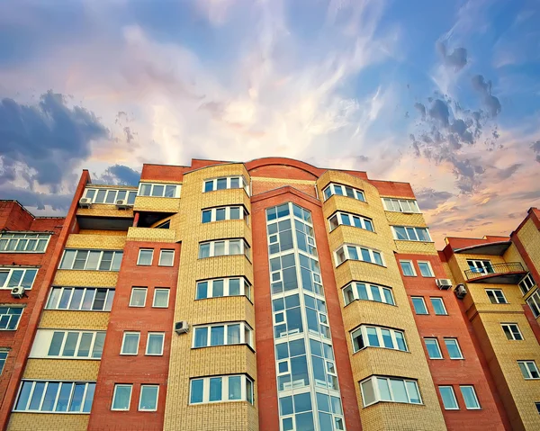 The new multi-storey apartment brick building against the sunset