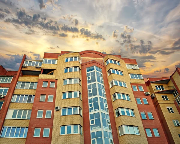 The new multi-storey apartment brick building against the sunset