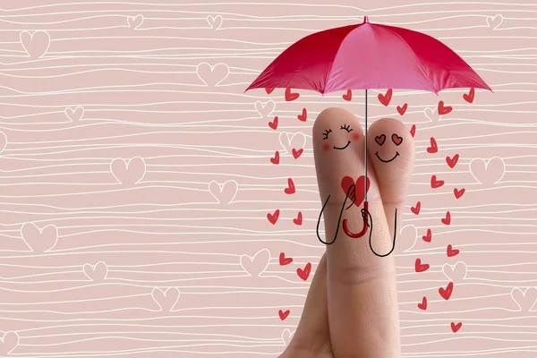 Finger art. Lovers is embracing and holding red umbrella. Stock Image