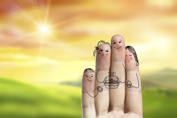 Conceptual easter finger art. Family are holding busket with painted eggs. Stock Image
