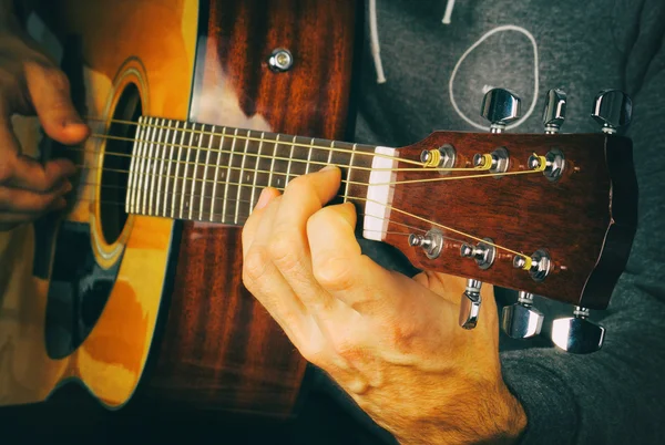 Man\'s hand playing the guitar.