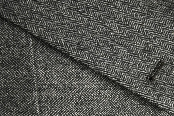 Lapel and pocket of a classic gray tweed coat