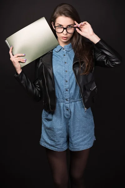 Beautiful young woman in glasses on a black background
