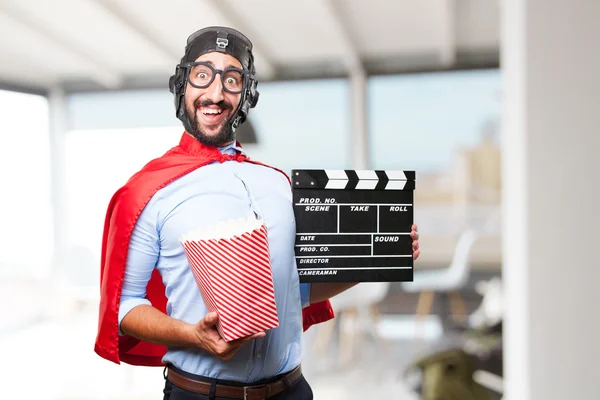 Crazy hero man with clapper board and popcorn