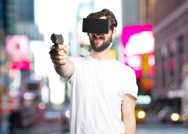 Young man in virtual glasses with pistol