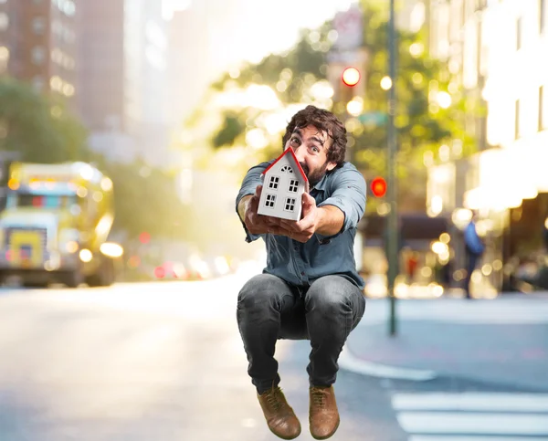 Crazy jumping man with toy house