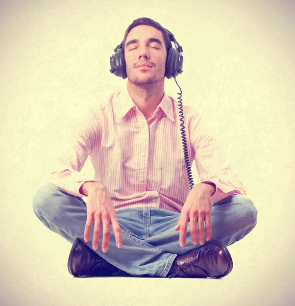 Young man listening music by headphones.