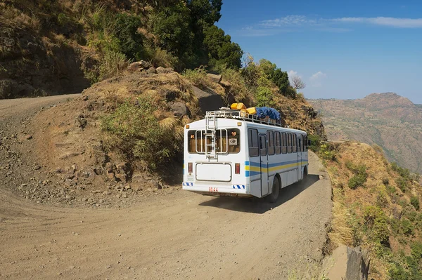 Tourist bus pass by the gravel mountain road in Axum, Ethiopia.