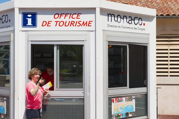 Woman gets maps and directions at the office of tourism booth in Monaco.