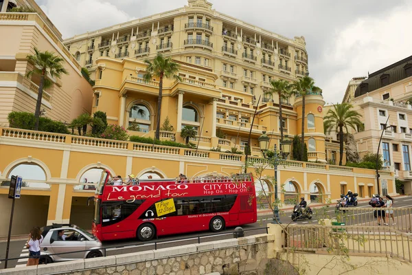 People enjoy sightseeing tour on the red Monaco city tour bus in Monaco.