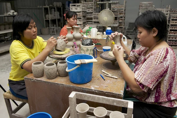 Women cut traditional tribal tattoo motives decoration at the raw kaolin in Kuching, Malaysia.