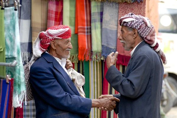 Two men shake hands at the market in Sana'a, Yemen.