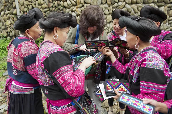 Women sell souvenirs to a tourist in Longji, China.