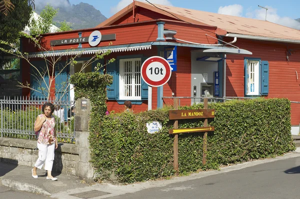 Woman walks by the street of Fond de Rond Point in Saint-Denis De La Reunion, France.