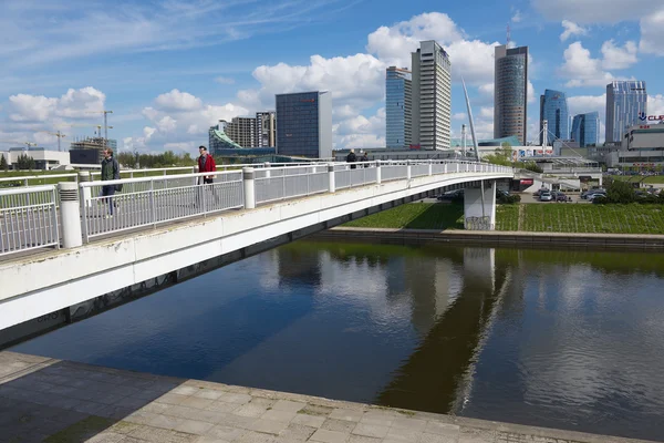 People walk by the white bridge in Vilnius, Lithuania.