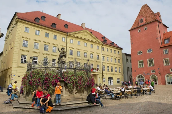 People enjoy time at the square of the historical part of Regensburg, Germany.