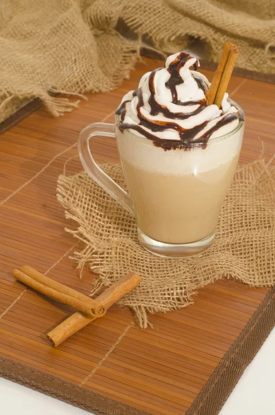 Iced coffee with foam and cinnamon on canvas