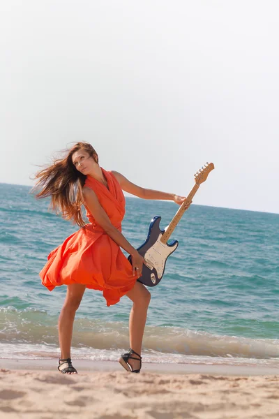 Girl with a guitar on the beach