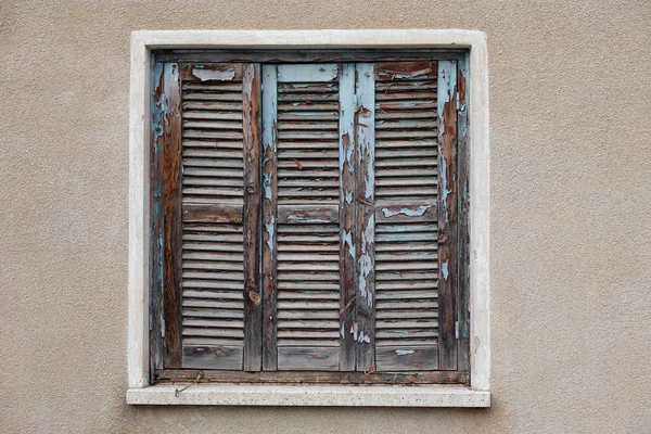 Old window with closed shutters