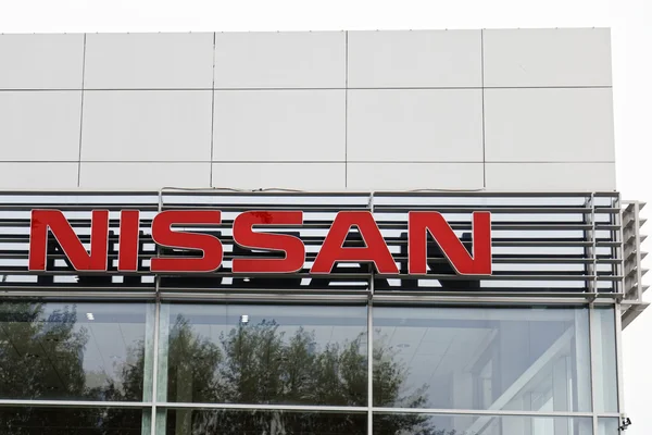 A Nissan sign on the building car selling and service center.