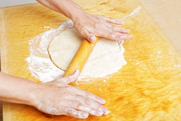 Housewife rolls dough for the pie