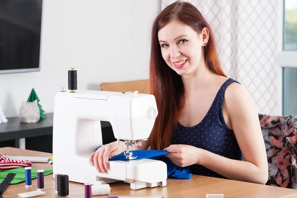 Young woman sewing fabric