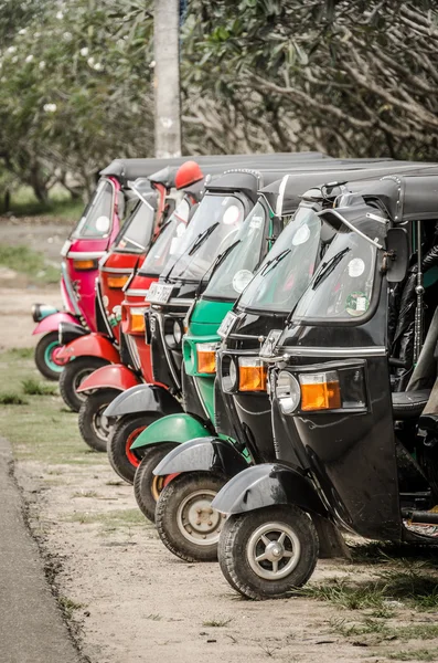 A row of neatly parked tuk tuk auto rickshaws