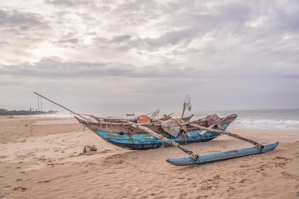 Wooden fishing boat on the beach of the atlantic ocean at the cloudy day.