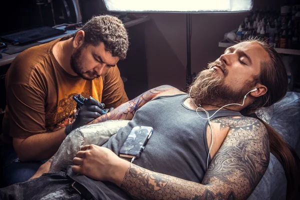 Professional tattoo artist makes cool tattoo in tattoo parlor