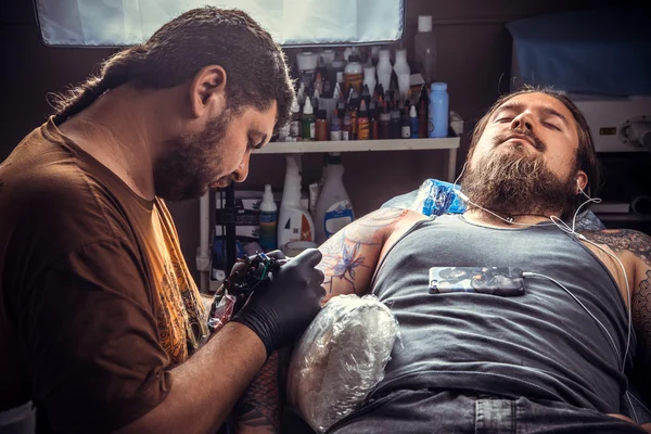 Tattoo master making a tattoo in tattoo parlor