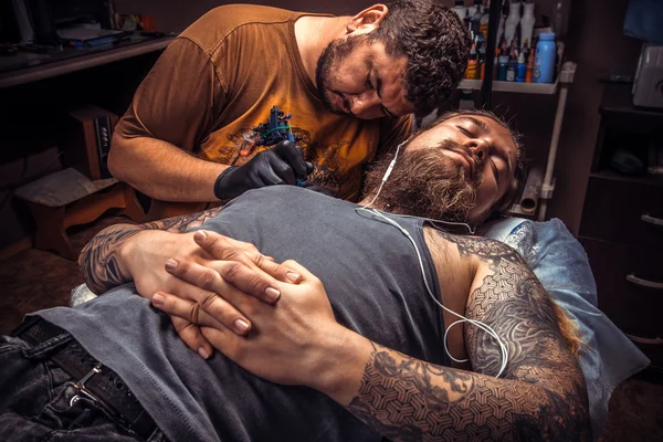 Tattooer doing tattoo in tattoo parlor