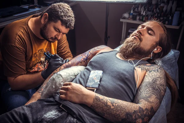 Tattoo artist works in tatoo salon