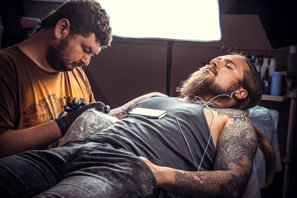 Tattoo artist works in tattoo parlour