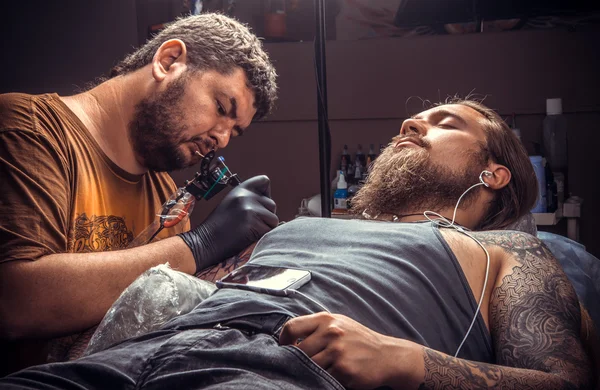 Tattoo artist at work in tatoo salon