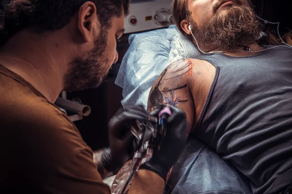 Tattoo master create tattoo in tatoo salon