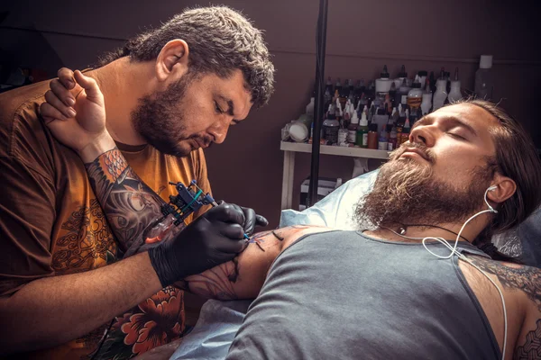 Master makes cool tattoo in tattoo studio