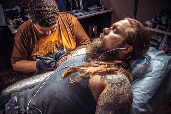 Tattoo master at work in tattoo studio