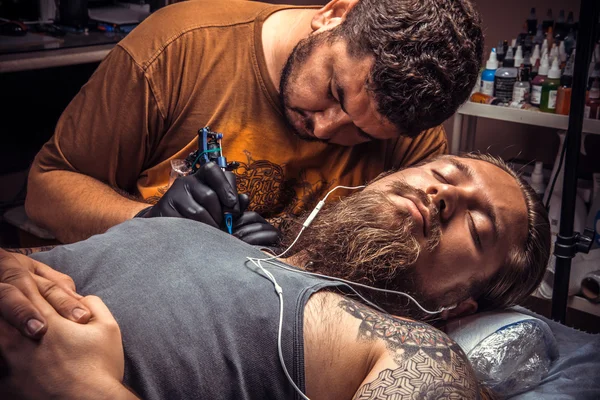 Tattoo artist working tattooing in tattoo parlour