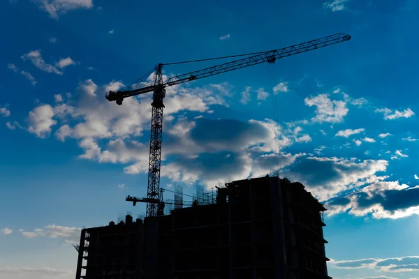 Industrial construction cranes and building silhouettes